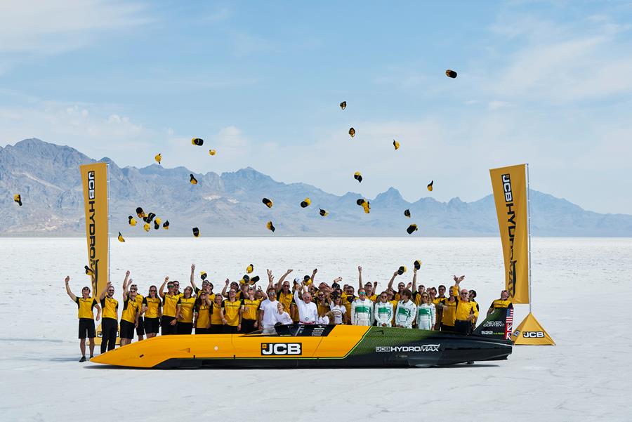 De JCB Hydromax en het team op de Bonneville Salt Flats na de recordpoging. De door twee waterstofverbrandingsmotoren aangedreven wagen noteerde over twee runs een gemiddelde snelheid van 406,320 mph (653,9 km/u). Het record wacht nog op officiële FIA-homologatie