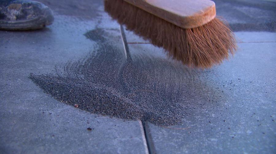 zand schuin in de voeg vegen