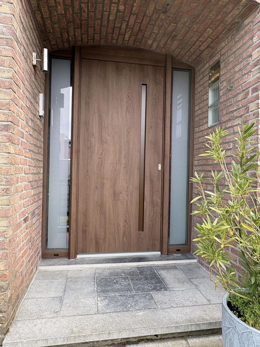 De combinatie van houtdecor, glas en maatwerk zorgt voor een harmonische integratie in de gevel